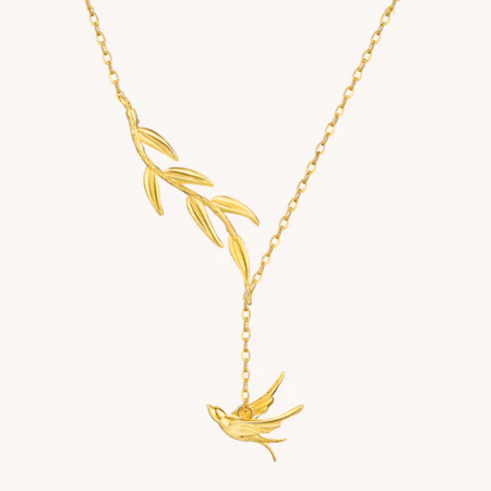 Gold necklace with a bird pendant on a white background