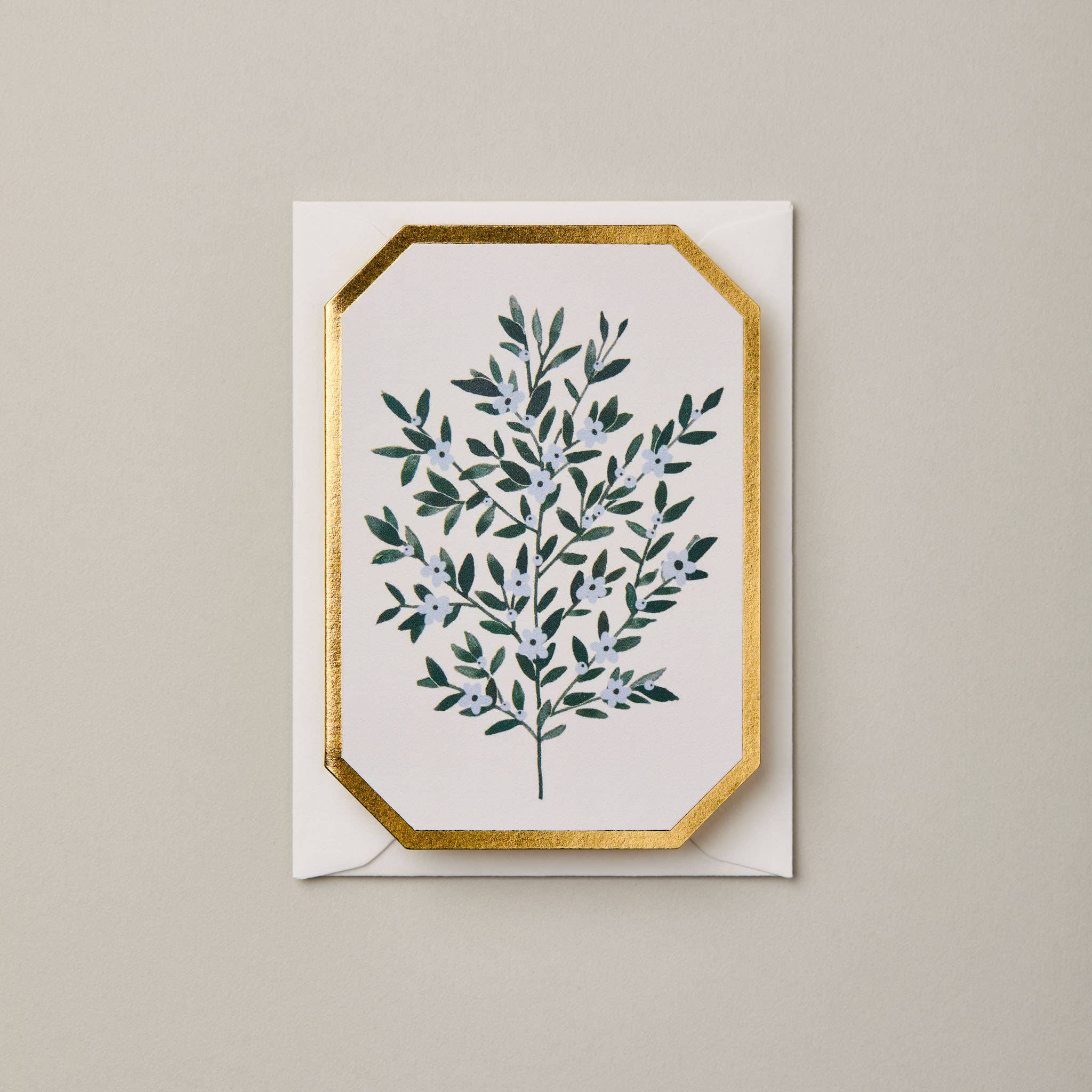 Greeting card with green leaf design and gold border on beige background