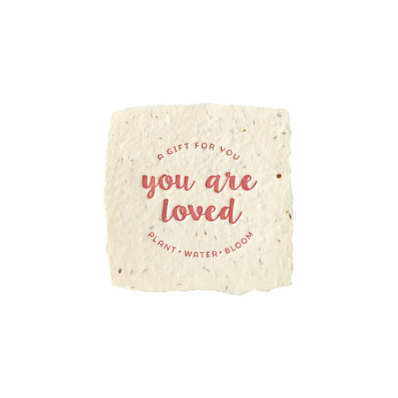 Seed paper square with 'You are loved' text on a white background