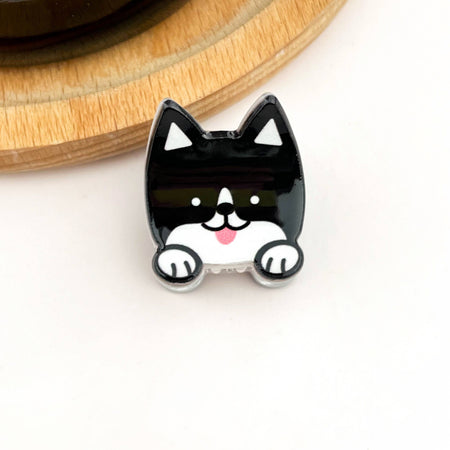 Black and white dog-shaped hair clip on a light background