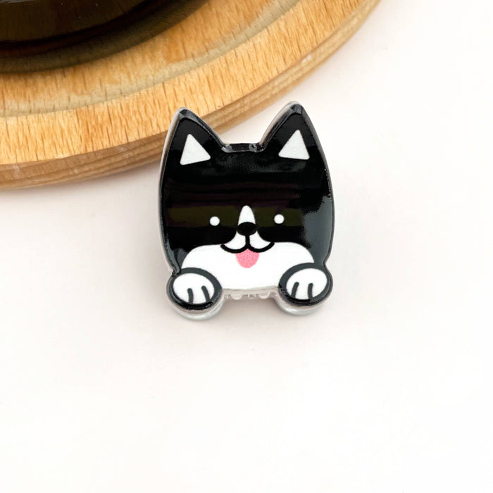 Black and white dog-shaped hair clip on a light background