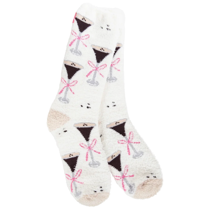 A pair of white fuzzy crew socks with a repeating pattern of martini glasses filled with dark liquor and tied with pink bows, shown on a plain white background.