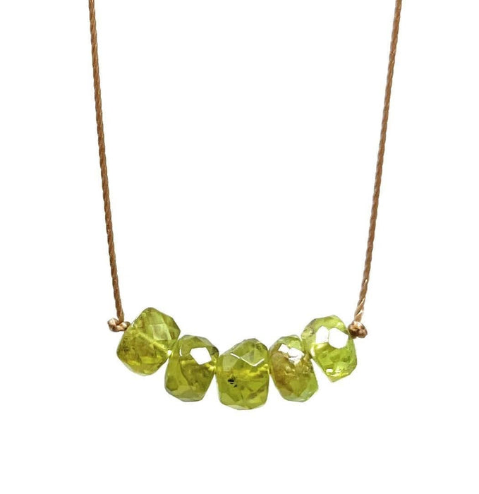 Necklace with peridot beads on a white background