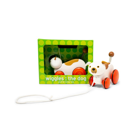 Toy dog with a green box labeled 'Wiggles the dog' on a white background