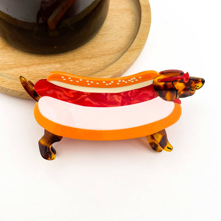 Hot dog-shaped hair clip with tortoiseshell accents on a white background