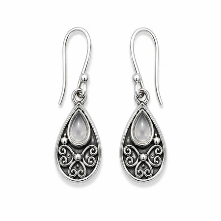 A pair of silver-toned teardrop dangle earrings with ornate filigree detailing and a small teardrop-shaped clear stone at the top of each earring, shown on a plain white background.