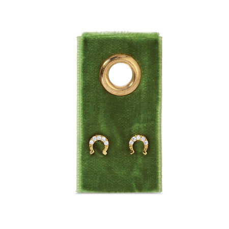Gold earring on a green velvet stand with a white background