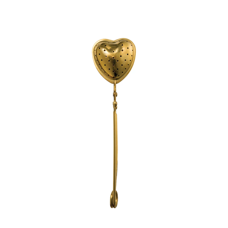 A gold heart-shaped stainless steel tea strainer with a handle and a perforated surface for tea infusion.