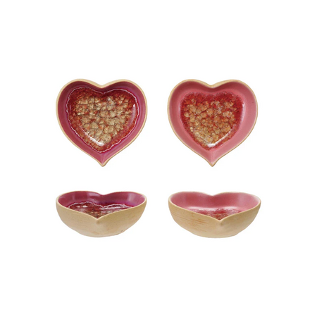 heart-shaped ceramic bowls with a pink interior and gold exterior on a white background.