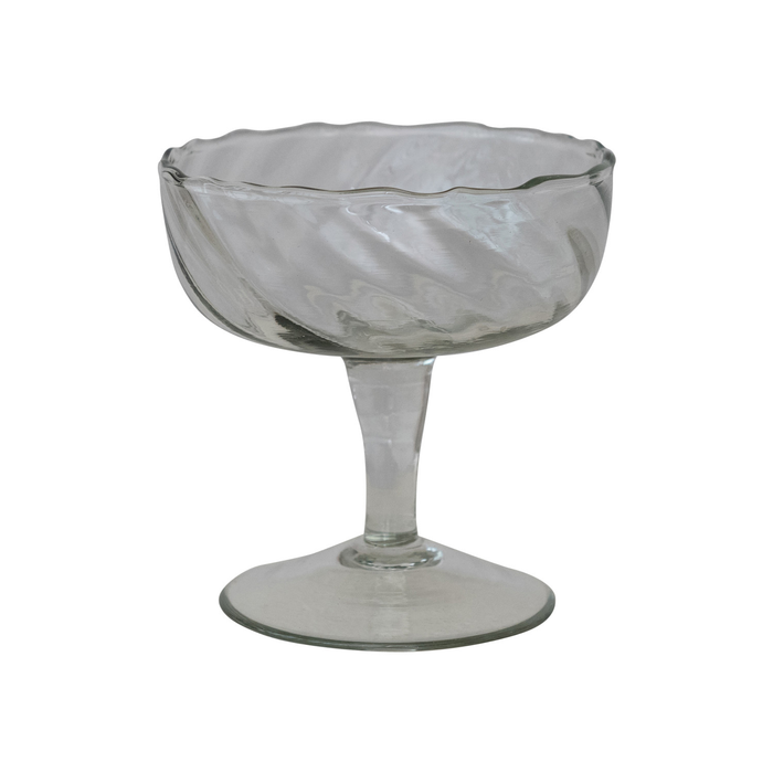 Clear glass footed coupe glass on a white background