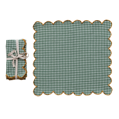 Green checkered placemat with scalloped edge and matching folded napkin on a white background