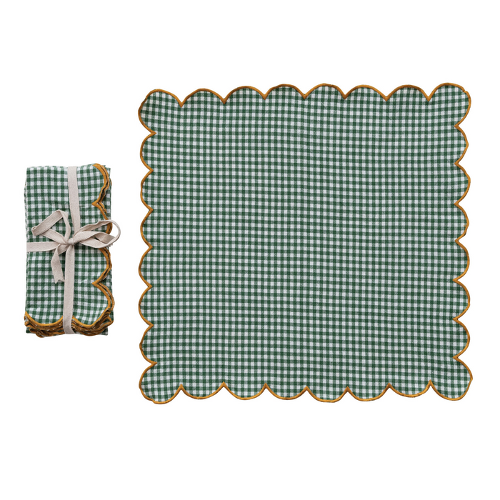 Green checkered placemat with scalloped edge and matching folded napkin on a white background