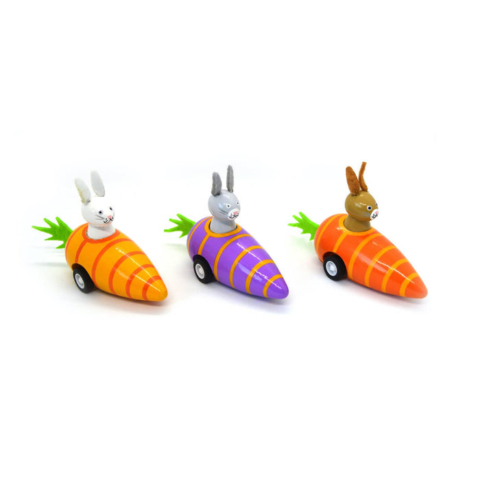 Three toy carrot cars with rabbit figures on a white background
