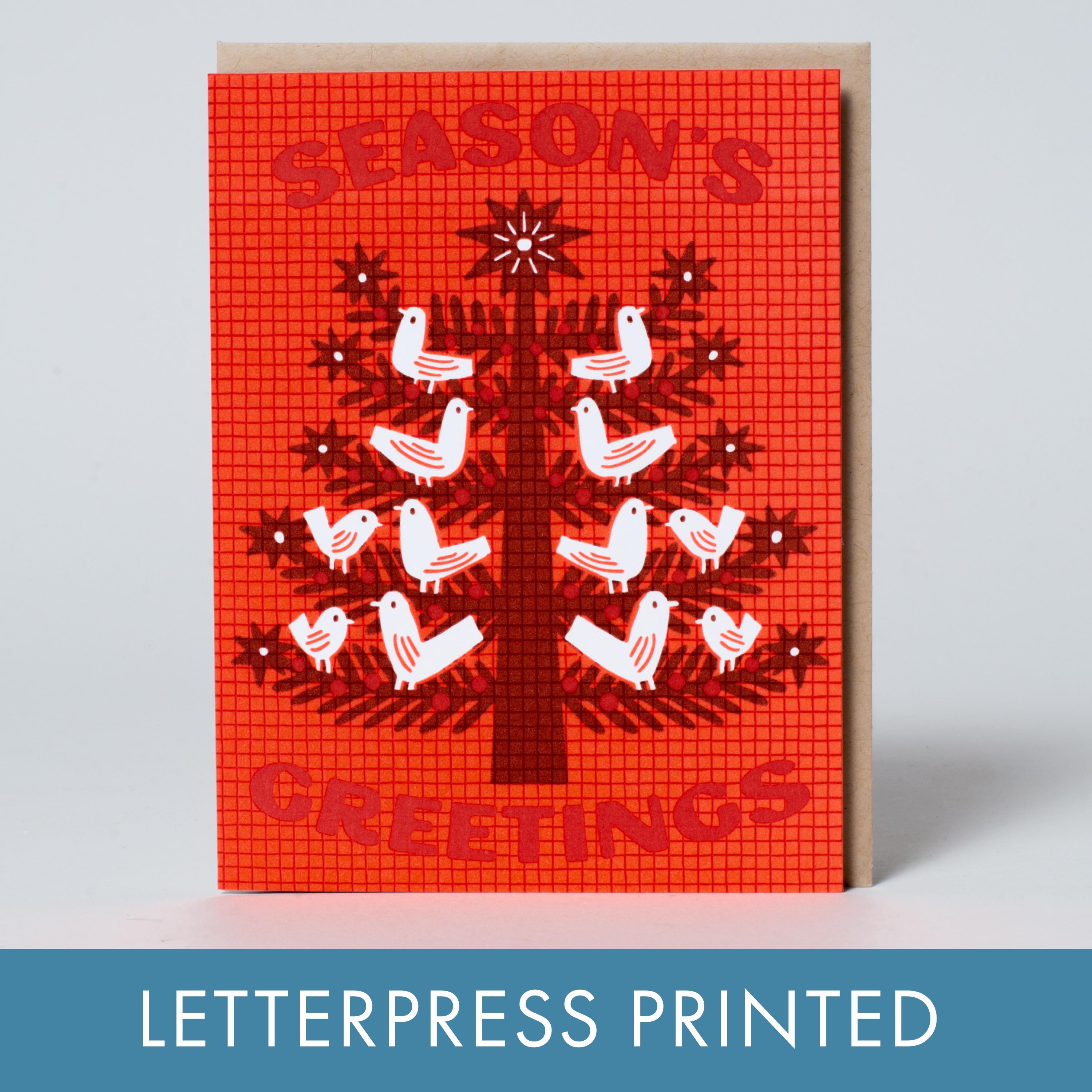 Red greeting card with a tree and birds design, labeled 'Season's Greetings', on a light gray background.