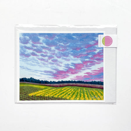 artwork of a colorful sky over a wine country field with a white border.