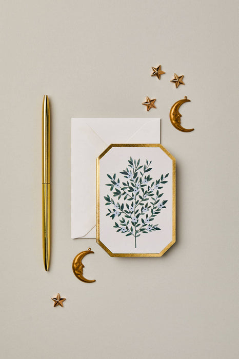 Decorative card with green leaf design, gold pen, and decorative elements on a beige background