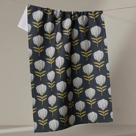 Floral patterned towel hanging on a line against a neutral background