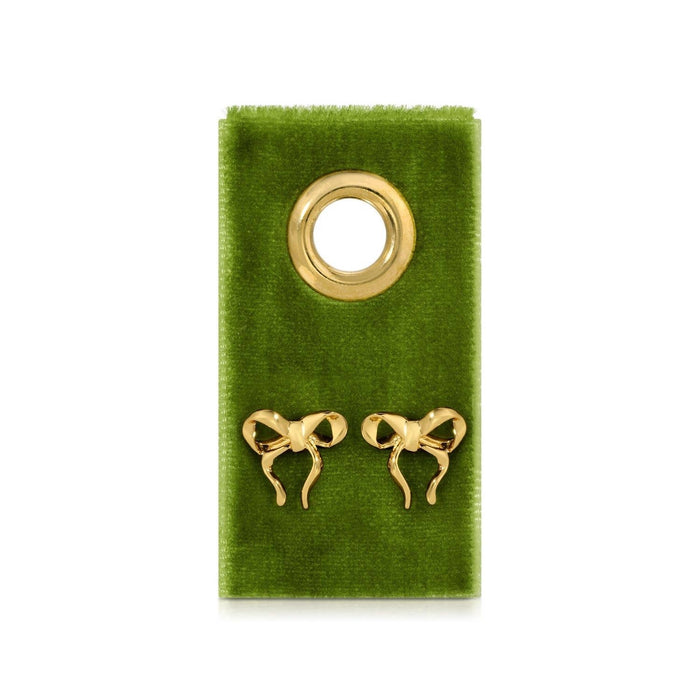 Gold bow-shaped earrings on a green velvet card 