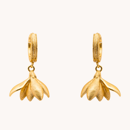 Pair of Magnolia Gold Loops earrings with sculptural brushed gold-tone flower petals hanging from small hoops.