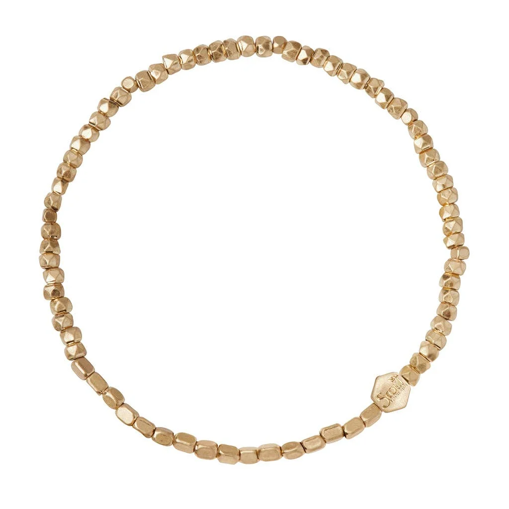Gold beaded bracelet on a white background