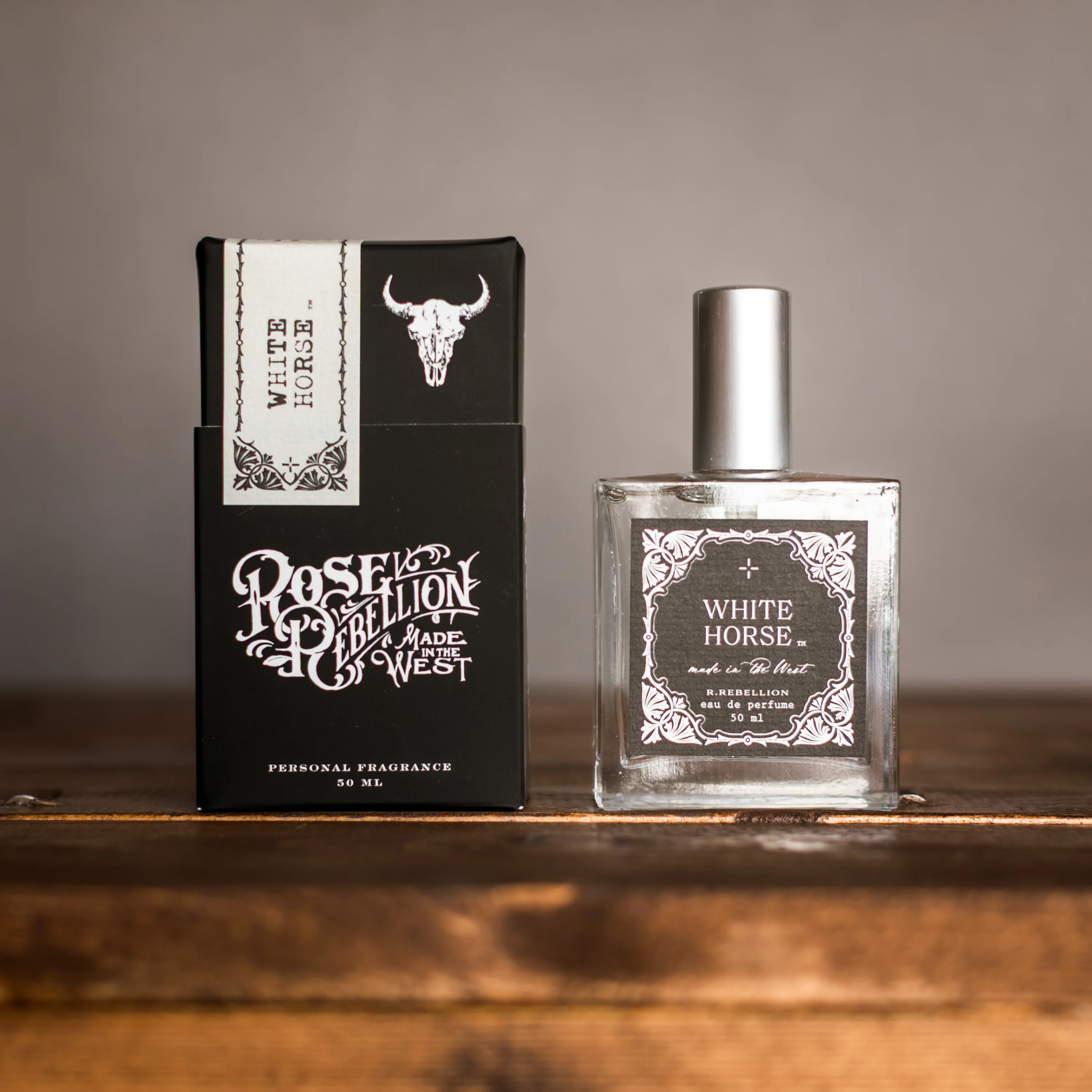 Perfume bottle and packaging of 'White Horse' by Roselion on a wooden surface.
