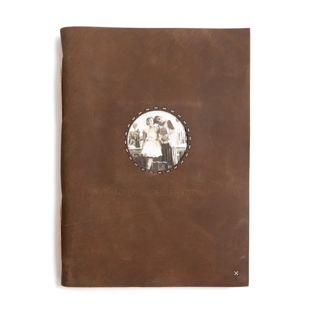 Brown leather-bound book with a circular photo holder on the cover