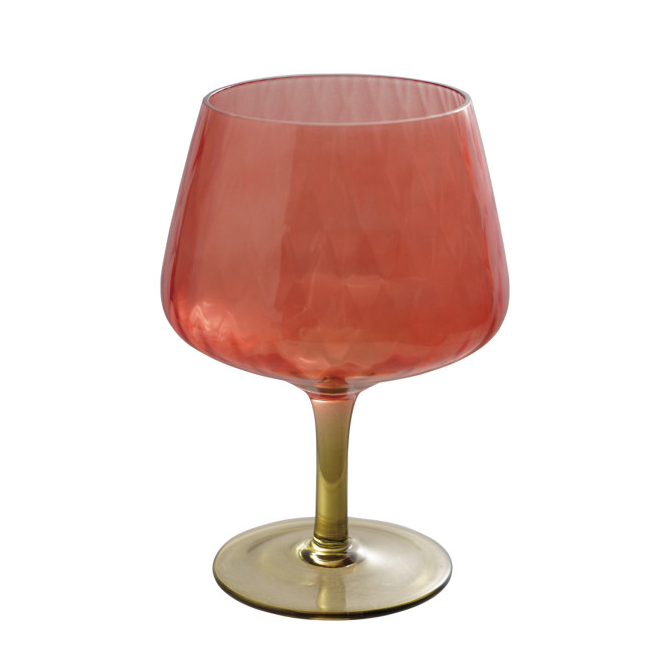 Red wine glass with gold base on a white background