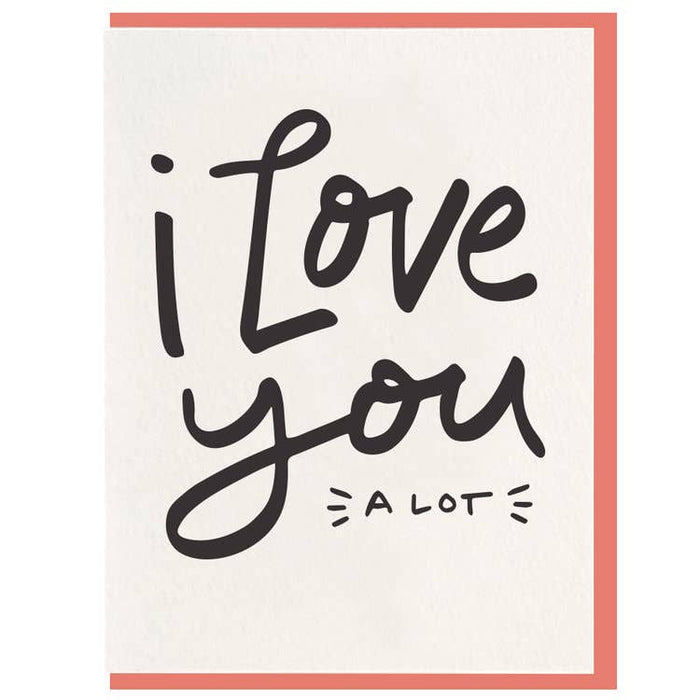 white card that reads "i love you a lot" with a peach colored envelope