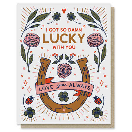 Damn Lucky Love Card with a golden-brown horseshoe, pink flowers, green clovers, and ladybugs surrounding a romantic message.”