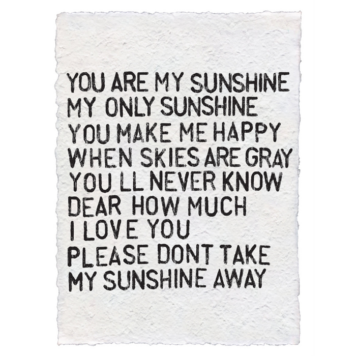 A handmade paper artwork with the text 'You are my Sunshine' printed on it, featuring deckled edges.