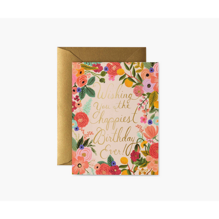 A floral birthday card with metallic gold foil stamping, featuring a colorful depiction of flowers and text that reads 'Wishing you the happiest birthday ever!' in a blank interior for a personal message.